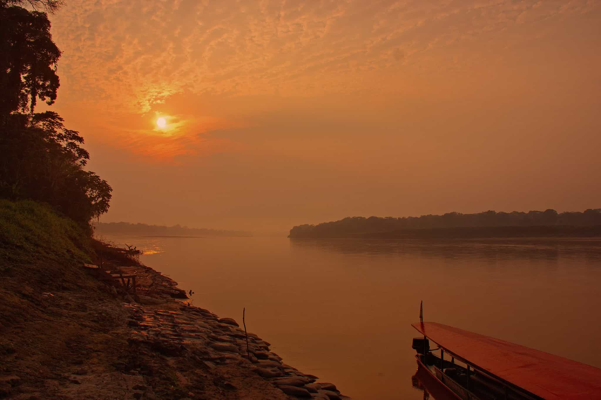 Early morning boat on the Rio Tambopata at sunrise