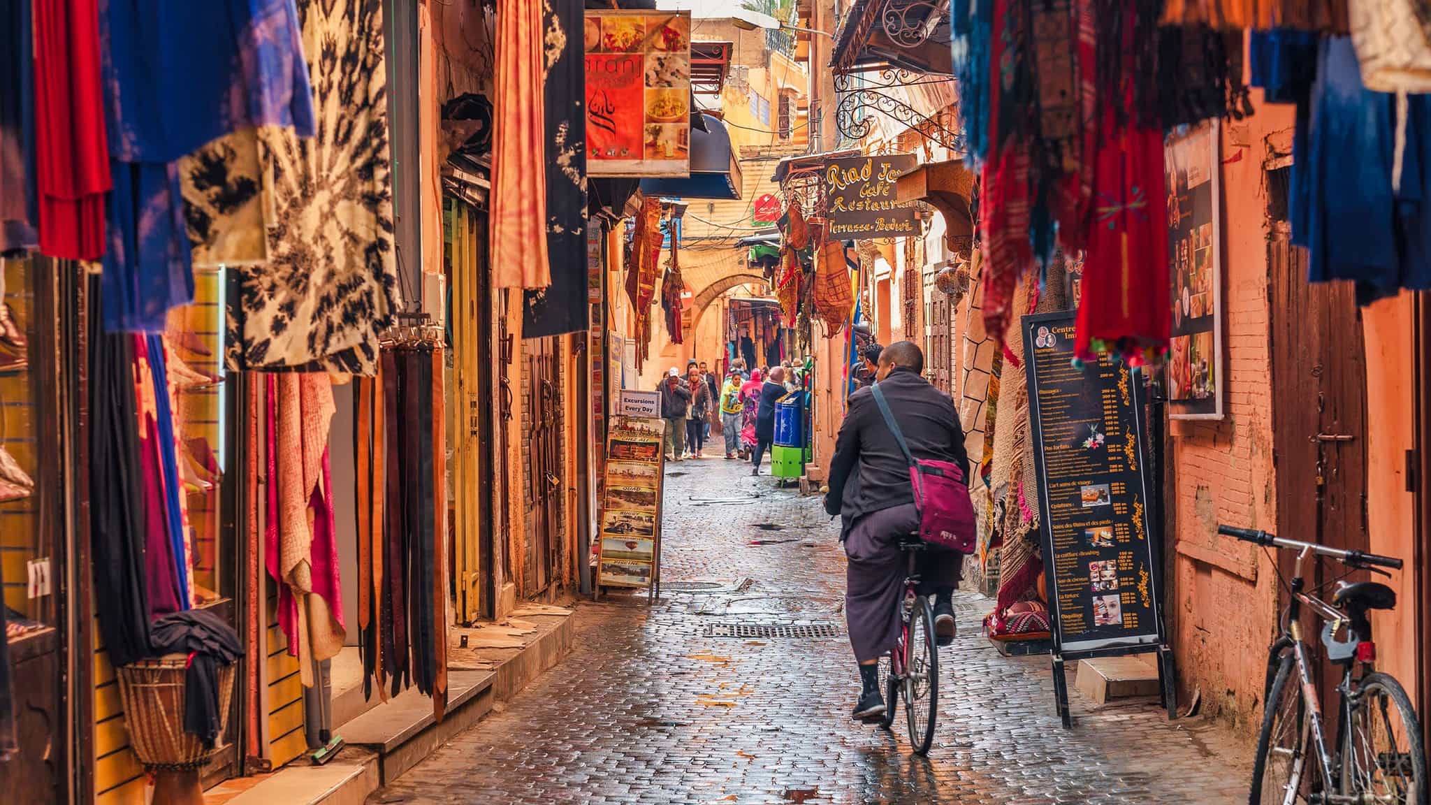 A cyclist cycles through the backstreets of Marrakesh, Morocco.