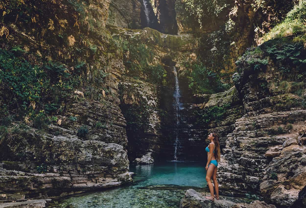 Woman standing by the Nivica canyon waterfall, Albania.