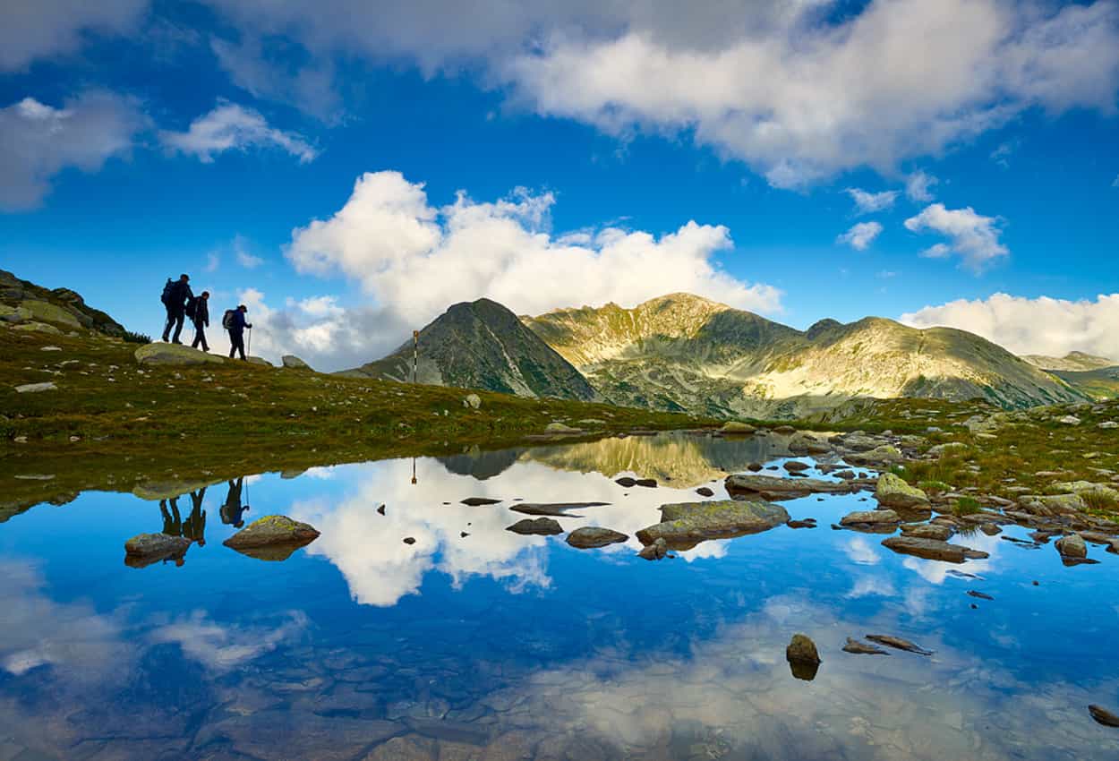 Hikers by glacial lakes in the Retezat Mountains, Romania.