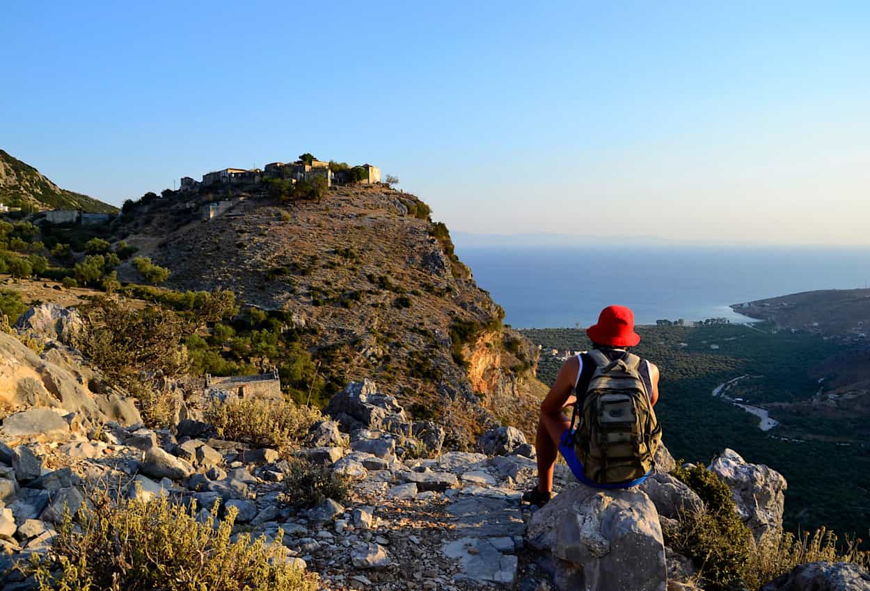 Young man looking at the sea and old village of Queparo in albanian mountains.