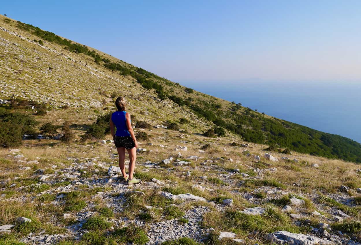 Woman hiking in Llogara National Park looking down to Ionian Sea, Albania.