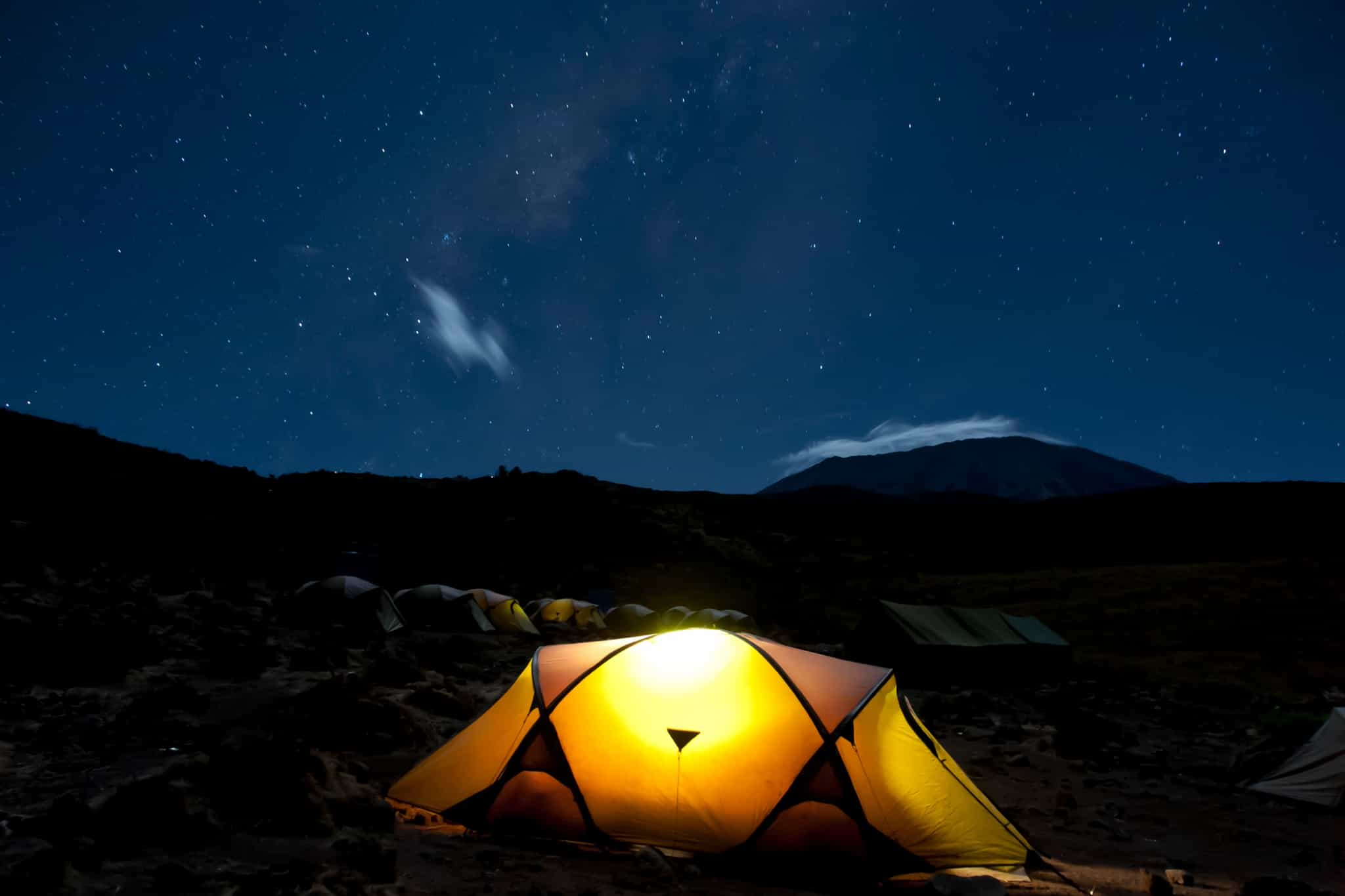 Illuminated tent at night at the Kikelelwa Cave campsite on the Rongai Route, Mount Kilimanjaro.