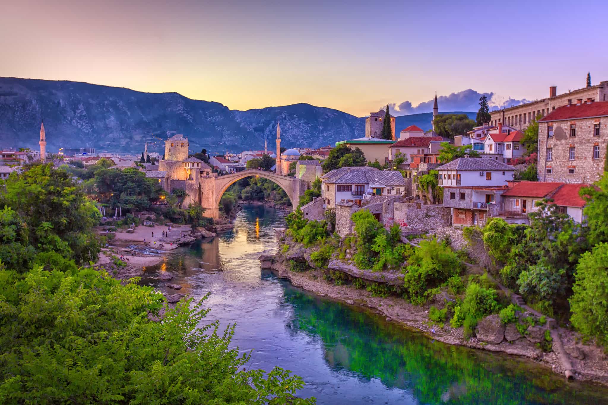 The old Mostar bridge crossing the Neretva River at sunset