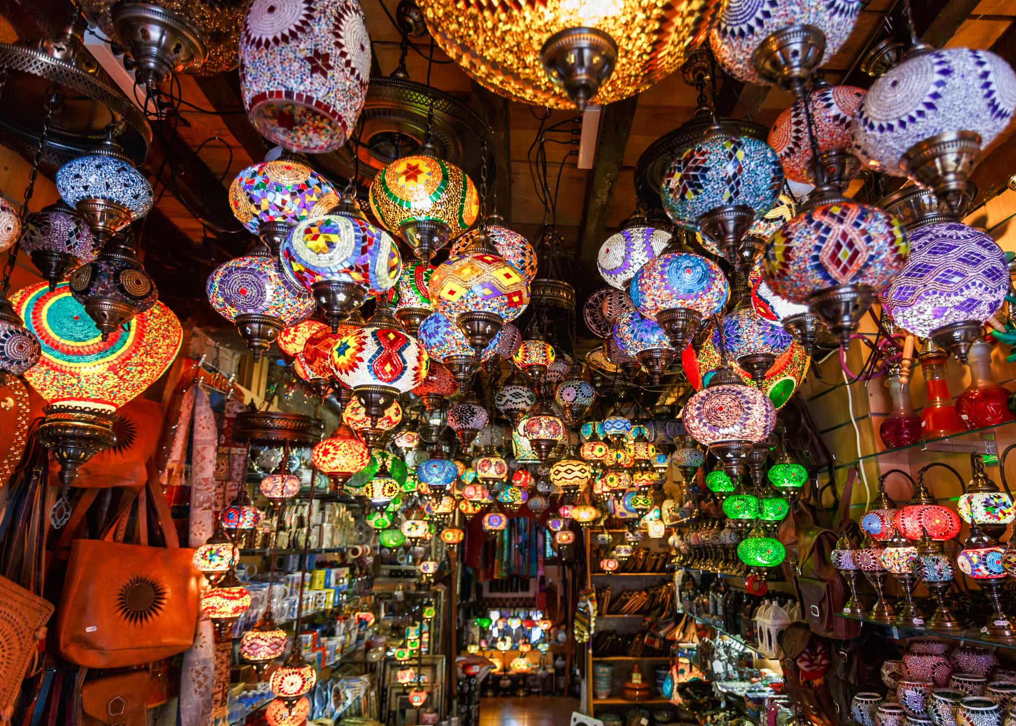 Colourful lights and lanterns hang from the ceiling of a souk in Morocco.